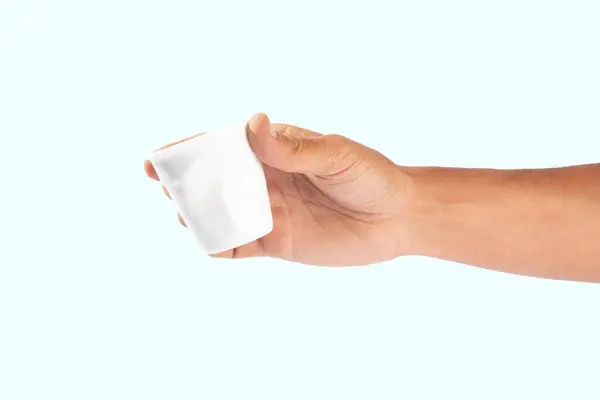 Erkek el, arka planda izole edilmiş buruşuk plastik bir bardak tutuyor. Yüksek kalite fotoğraf