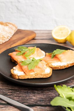 Füme ve tuzlu somon tostları roka ile servis edilir, sağlıklı kahvaltı. Yüksek kalite fotoğraf