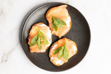 Mutfak tezgahında izole edilmiş tütsülenmiş somon tostlarının üst görüntüsü. Yüksek kalite fotoğraf