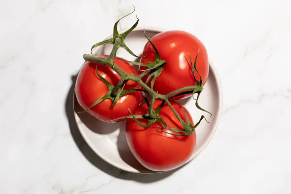 Mutfak tezgahında izole edilmiş beyaz tabakta servis edilen domatesler. Yüksek kalite fotoğraf