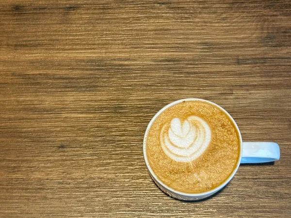 Latte Belegt Mit Blattförmigem Milchschaum Und Holzmaserungstisch — Stockfoto