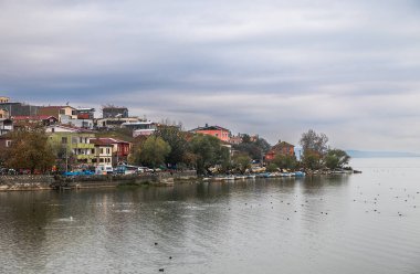 Uluabat Gölü kıyısındaki bir yarımadada kurulmuş olan köyün eski adı Apollonia 'dır. BC 'yi kurdu. Altıncı yüzyıla dayanıyor ve antik çağlarda 'Apollonia ad Ryndacum' olarak adlandırılıyordu..