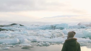 Jokulsarlon 'un manzarasını düşünen bir adam, İzlanda' da bir buzul gölü..