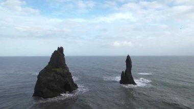 Reynisfjara 'da okyanusta iki kaya, Vik' in (Güney İzlanda) yanında siyah bir kumsal. Drone 'la çekilmiş. Portföyümde farklı pozlar var..
