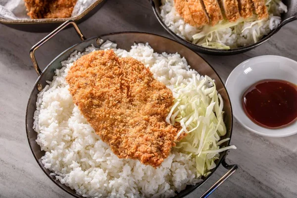 Crispy Pork Cutlet Perfection: Top Close-Up of Deep-Fried Pork Cutlets on Chopped Green Cabbage and Steamed White Rice, Captured in 4K Resolution