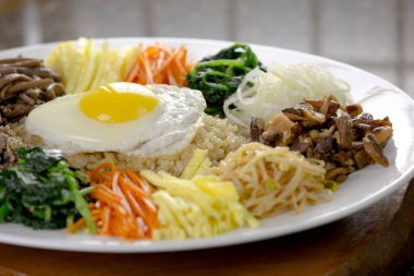 Canlı Bi Bim Bap Bowl: Renkli Sebzelerin 4K Ultra HD Görüntüsü ve Kahverengi Pirinç