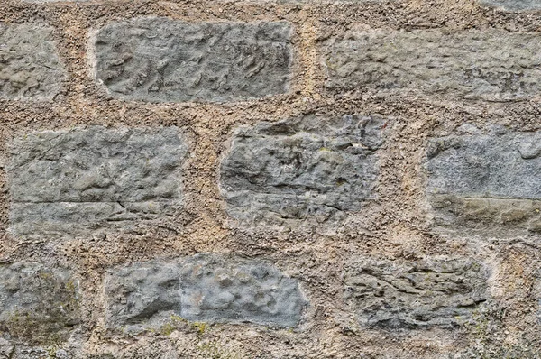 Duvar kağıdı gibi yıpranmış taş bir duvar.