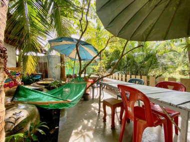 Sandalyesi, bitkisi, ağacı ve suyu olan tropik bir tatil köyü..