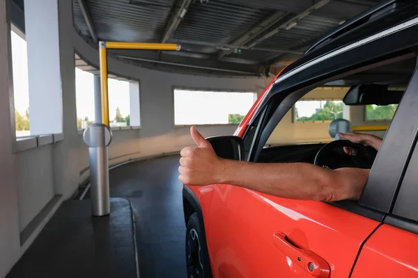 一个人在进入地下停车场时 用大拇指向上伸出的手 停车安全制度 — 图库照片