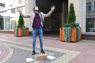 Duygusal, hayal kırıklığına uğramış genç bir adam, sokakta grevde olan tıbbi maskeli bir ofis çalışanı. Kriz, iş, yaşam tarzı. İşsizlik sorunu kavramı