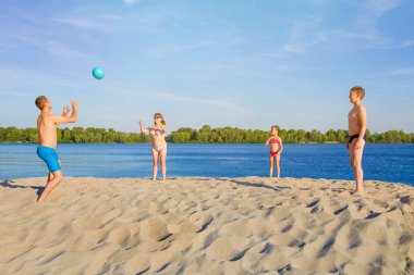 Mutlu aile kumsalda voleybol oynuyor. Sağlıklı yaşam tarzı kavramı. Aile tatili, yaz tatili