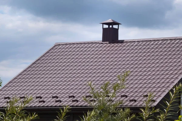 青い空に向かって煙突を持つ家の茶色の屋根 — ストック写真