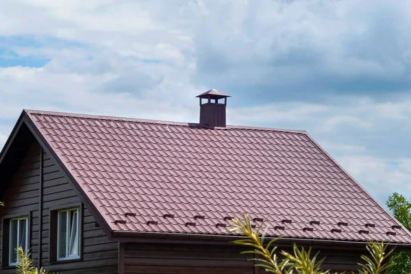 青い空に対して煙突と茶色のタイルの屋根 — ストック写真