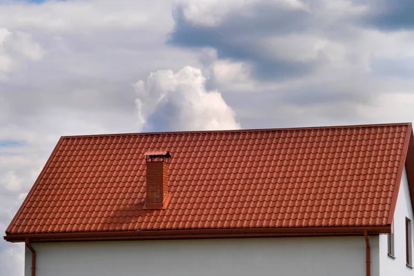 雲を背景に茶色の瓦屋根の家の一部 — ストック写真