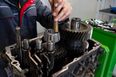 Bir araba tamircisi bir kamyon motorunu tamir eder. Garajdaki kamyon servisi. Onarım ve tanı, yakın çekim.