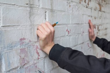 Duvarda şırınga olan eller. Uluslararası Uyuşturucu Bağımlılığı Günü. Bağımlılık kavramı.