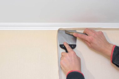 İşçi elleri ve macun bıçağı arka planda. İnşaat işi.