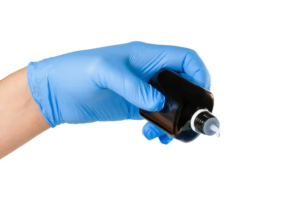 一只手戴着蓝色的医疗手套 手里拿着一瓶药瓶 药瓶的背景是白色的 用于防止传染性病毒的瓶子 健康概念 — 图库照片