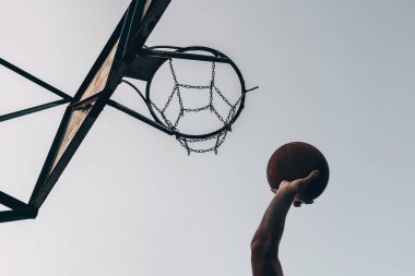 Topu ringe atan bir basketbolcunun silueti..