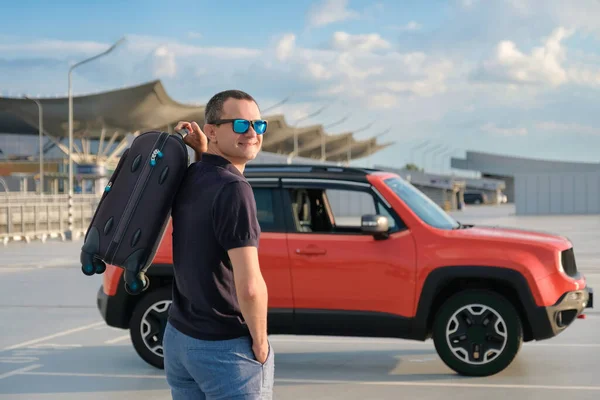 旅行概念 一个戴着太阳镜 手里拿着手提箱的快乐男人在机场停车场的画像 — 图库照片