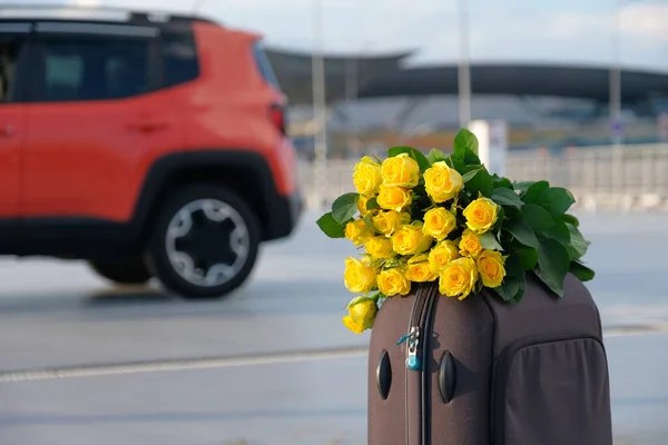 Ένα Μπουκέτο Λουλούδια Και Αποσκευές Στο Χώρο Στάθμευσης Φόντο Ένα — Φωτογραφία Αρχείου