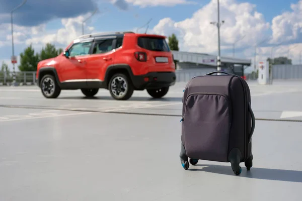 在停车场的汽车后面的一个行李箱 旅行概念 — 图库照片