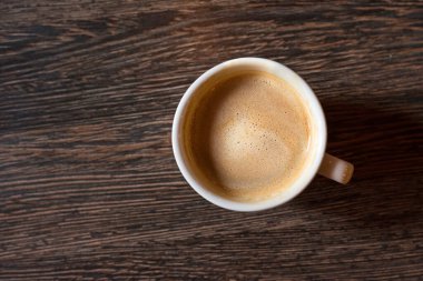 Ahşap bir arka plan üzerinde bir fincan kahve. Üstte görüntü.