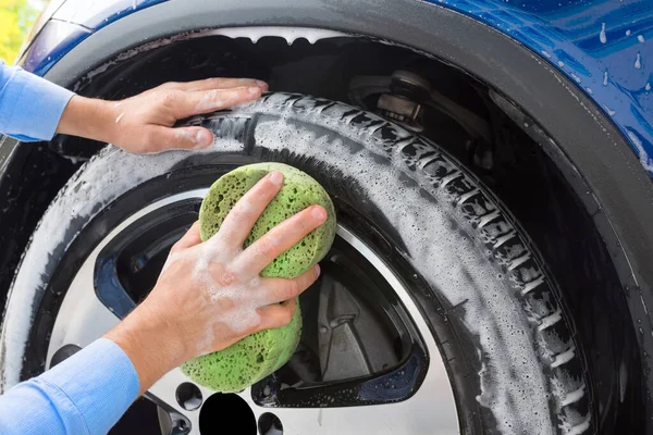 Man, washing the wheels of car on autowashing. Car washing.