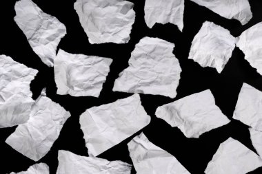 Siyah arkaplandaki ileti için yırtık kağıt parçaları.