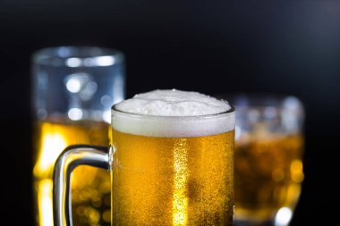 Siyah arka planda bir bardak light bira. Alkolik içecekler