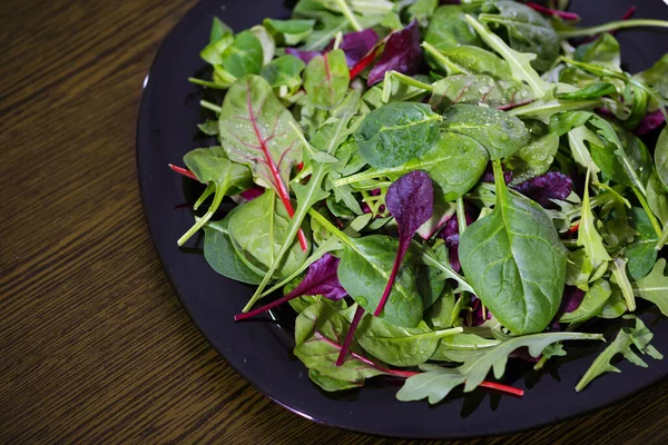 Salad Hijau Segar Piring Hitam Atas Meja Kayu — Stok Foto