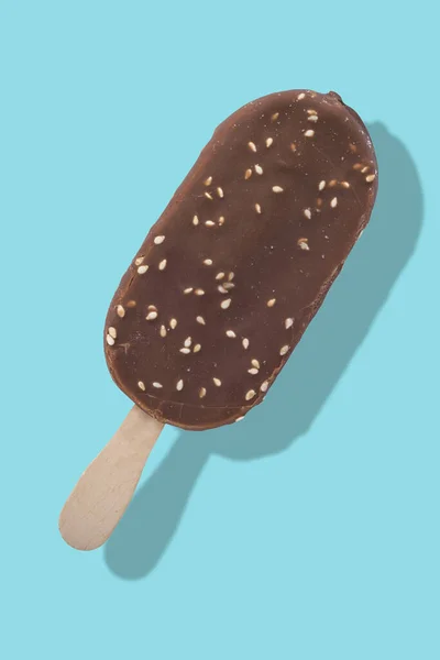 Шоколадное Мороженое Палочке Орехами Синем Фоне Отражением Разделения — стоковое фото