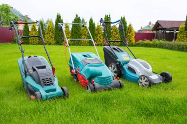 lawn mowers in the backyard. Gardening concept. Grass care. clipart