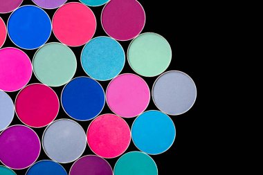 Siyah bir arka planda, çok renkli göz gölgelerinden oluşan bir paletin parlak renkli arka planı.