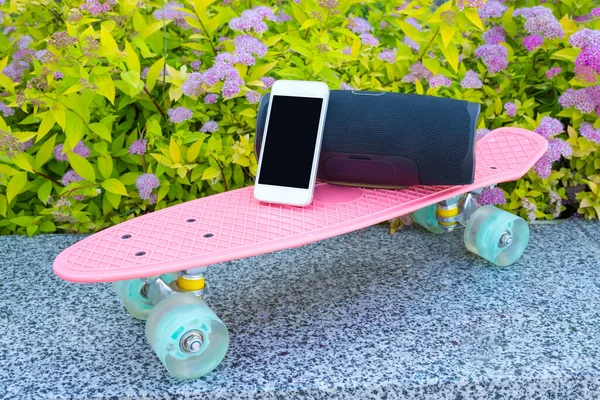 Smartphone Muzikale Zuil Een Skateboard Close Tegen Achtergrond Van Bloemen — Stockfoto