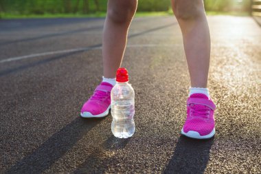 Güneşli bir günde çocuk ayakları spor sahasında. Spor yaşam tarzı.