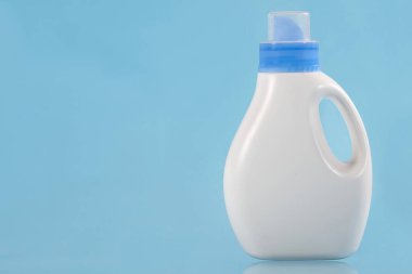 Mavi arka planda deterjan şişesi. Uzayı kopyala Temizlik kavramı.