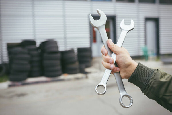 Car repairing,Hand of technician auto mechanic with a wrench working in garage. service in auto repair station.