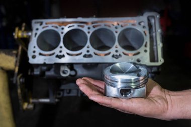 Motor silindiri bir tamircinin elinde. Araba servisi. Otomatik tamir kavramı.
