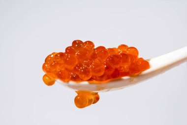 Kaşık, gri arka planda somon balığı kırmızı havyarı. deniz ürünleri.