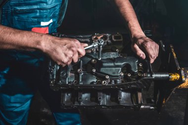 Otomobil tamircisi araba motorunu tamir ediyor. Garajdaki tamirat servisi..