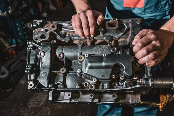 stock image Hands of auto mechanic and disassembled engine, close-up. Car maintenance concept.