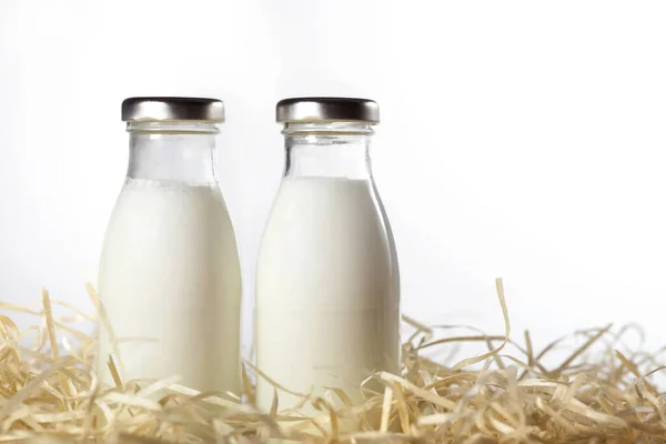 Μπουκάλια Φρέσκο Γάλα Στο Σανό Που Απομονώνεται Στο Λευκό Κοντινό — Φωτογραφία Αρχείου