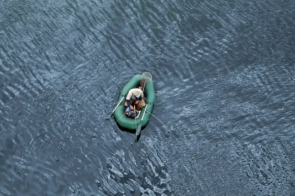 ゴムボートに乗った漁師が川で魚を捕まえる トップビュー クローズアップ ライフスタイル — ストック写真