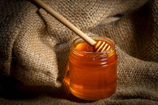 Υγρό Μέλι Μια Σταγόνα Μελιού Γυάλινο Βάζο Λινάτσα Κοντινό Πλάνο — Φωτογραφία Αρχείου