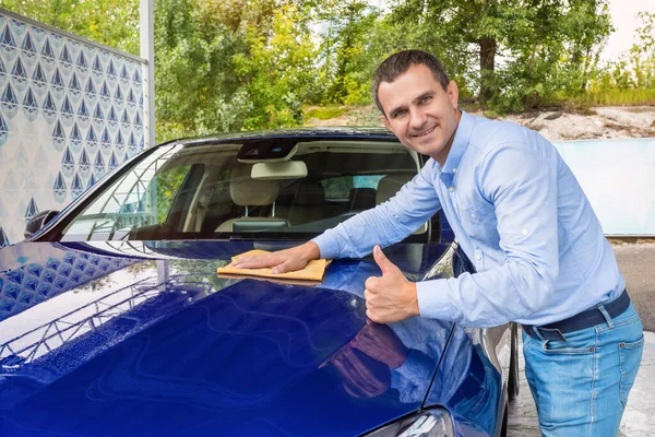 男人在洗车时擦亮汽车 男人手握微型纤维 擦亮了汽车 — 图库照片