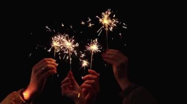 Yeni yılı gece kutlayan maytaplı insanların elleri. Noel tatili kavramı
