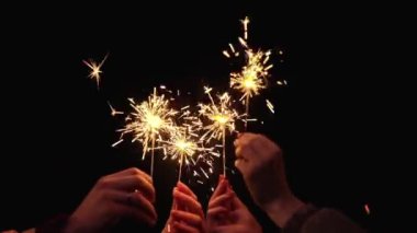 Yeni yılı gece kutlayan maytaplı insanların elleri. Güzel Bokeh ışıkları arka planda. Yeni yıl partisi, tatil konsepti.