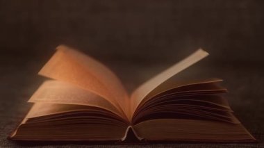 Eski bir kitabın sayfalarını düzgünce çevirmek. Kitap parıltısı, sihir.