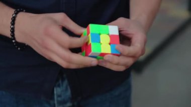 Akıllı bulmaca küpü toplayan bir gencin elleri. Genç bir adam entelektüel bir bulmacayı çözüyor..